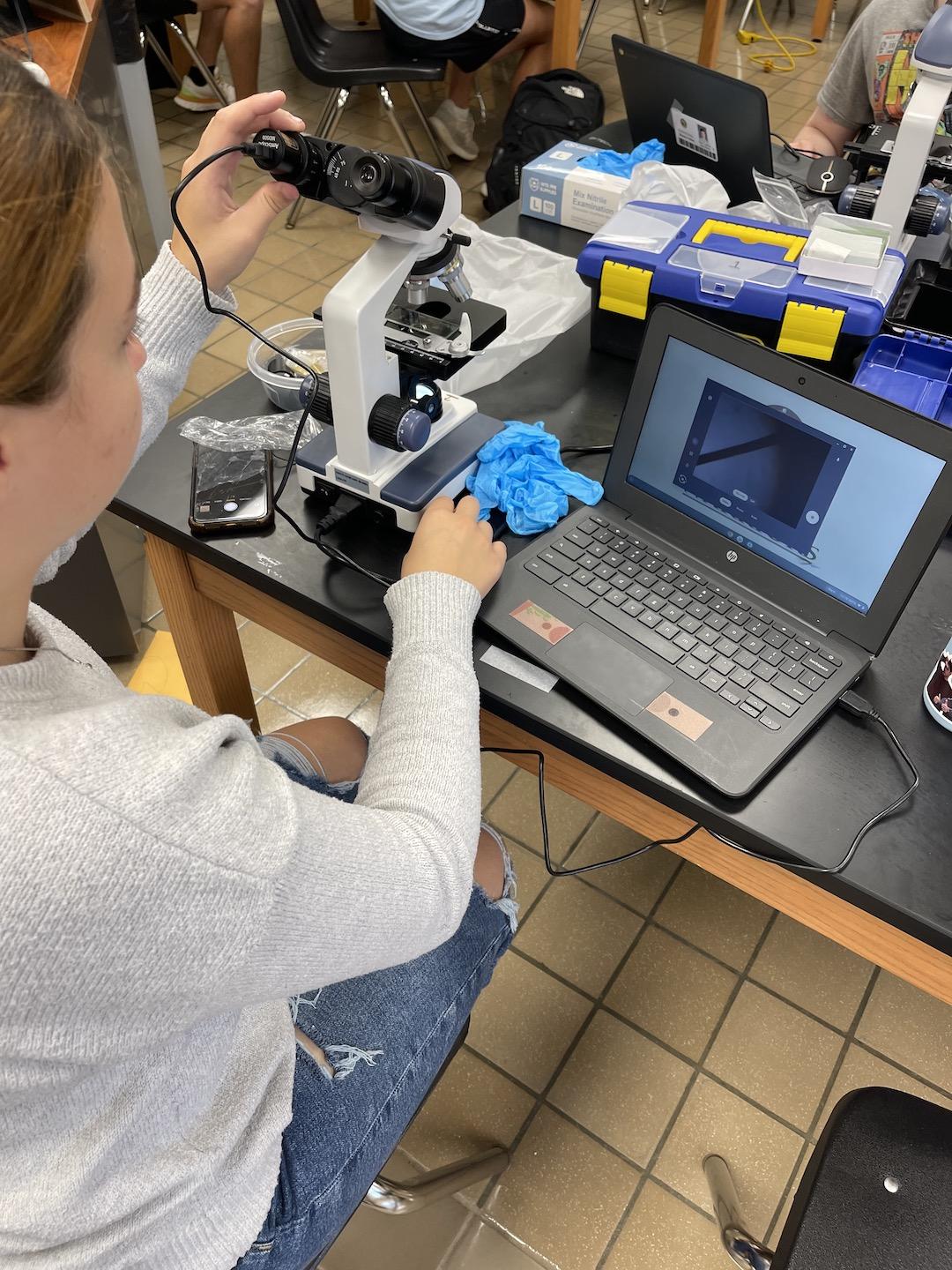 A student saves images from the microscope to her laptop