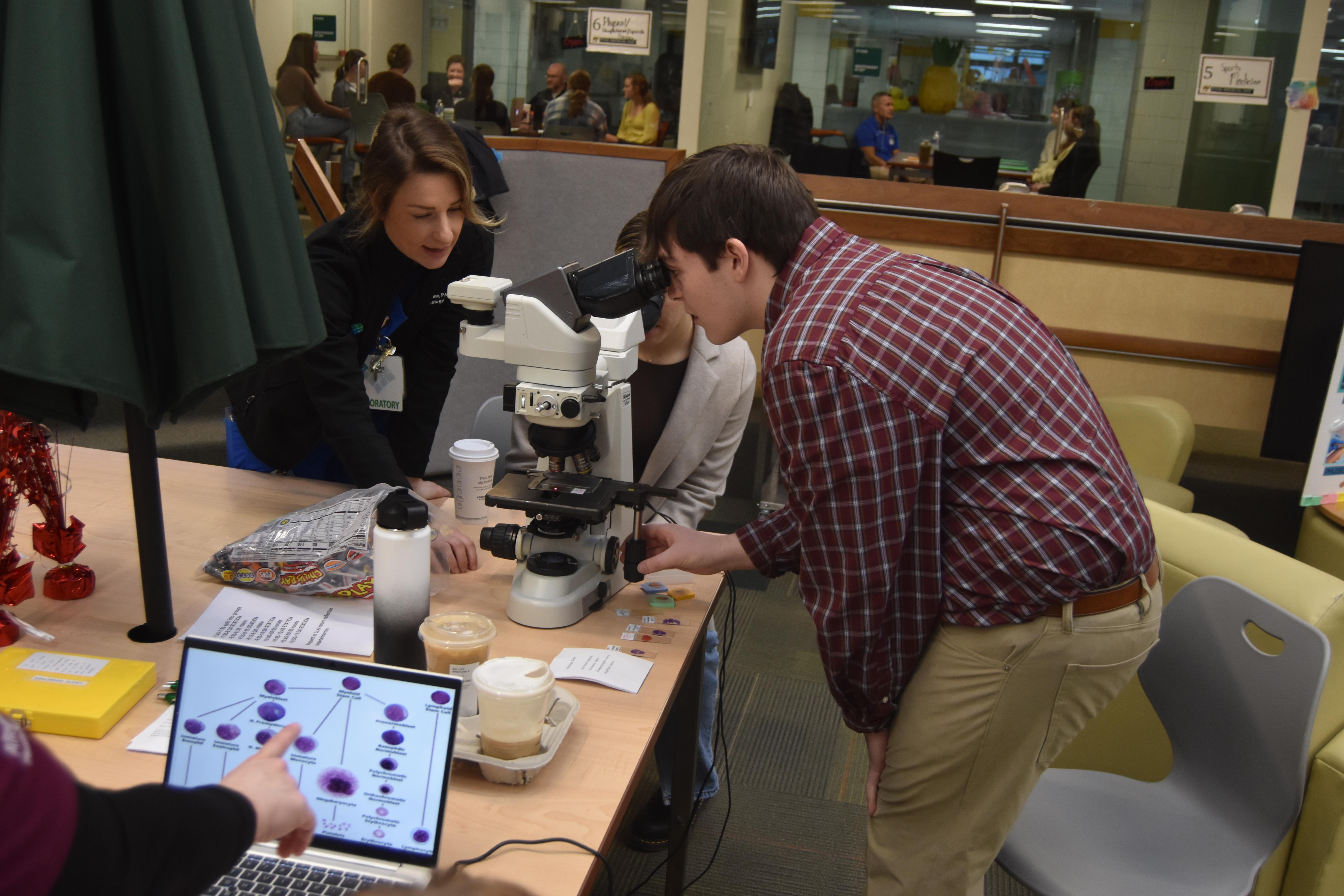 Pathologist Assistant Jennifer Stone explains the laboratory setting to student Zachary Burns