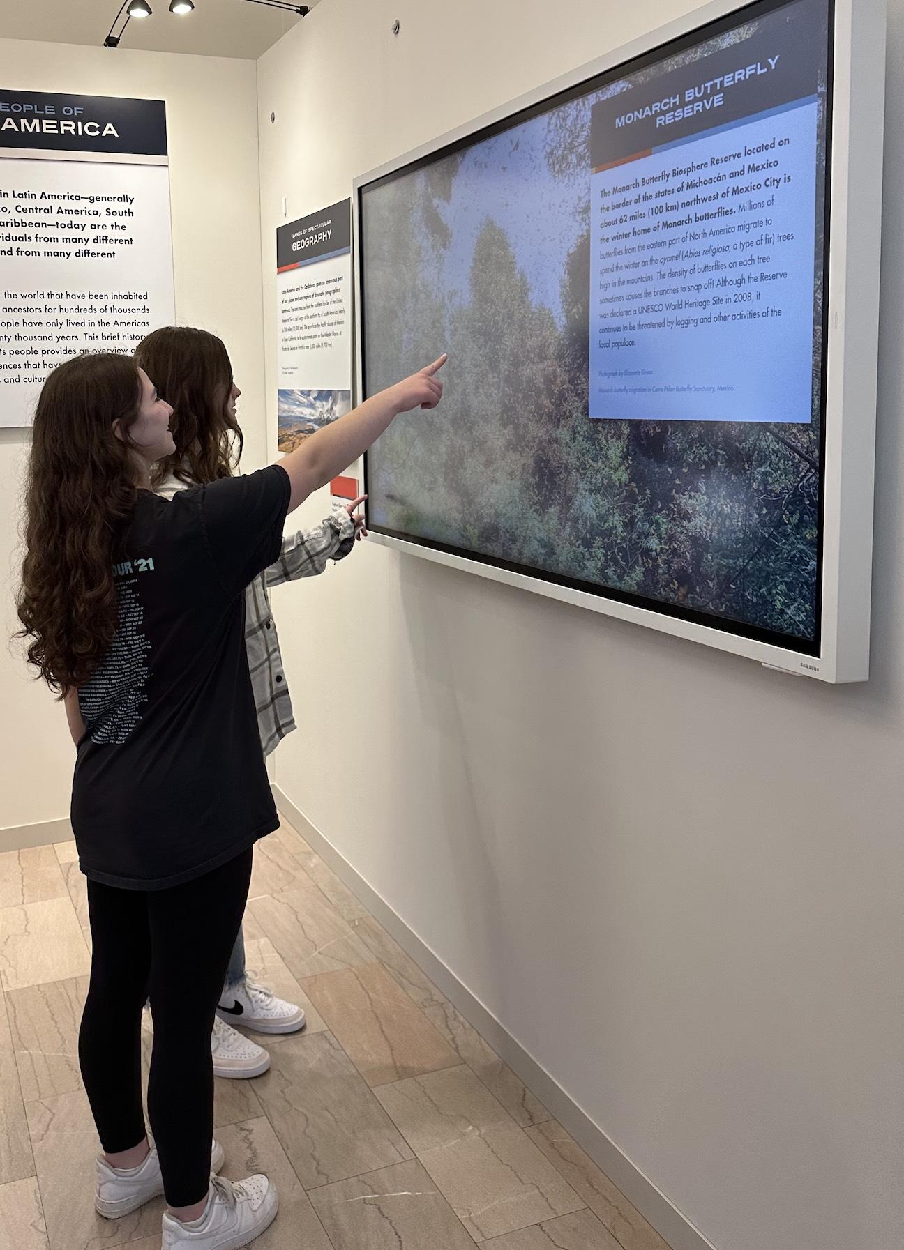 11th-graders Carlee Valenta and Madelyn Alexander pause at one of the exhibits