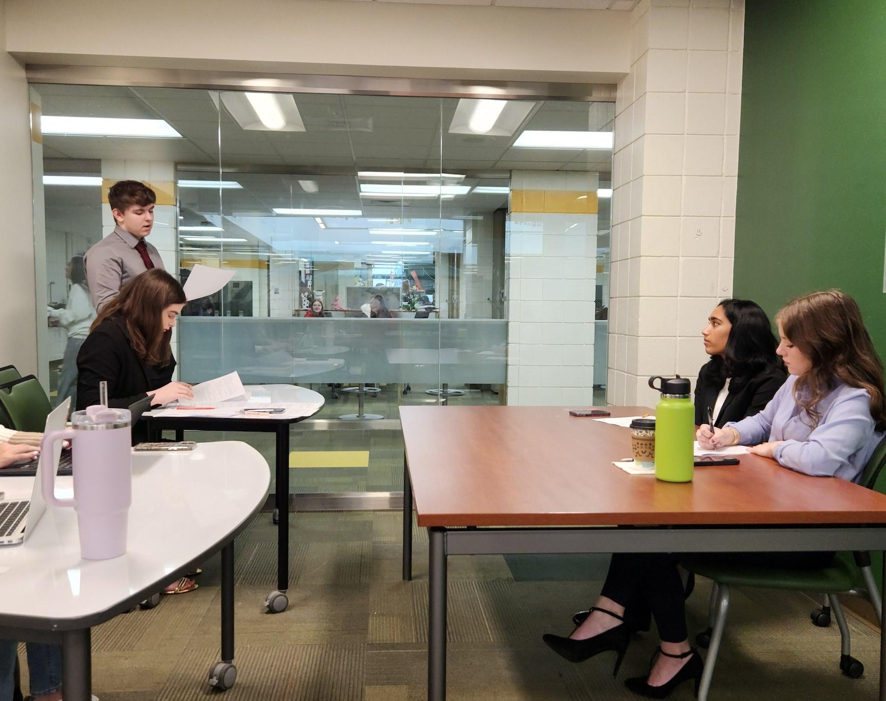 Josh and Alex (left) debate while 11th-grader Rachael Gill serves as a judge and 10th-grader Adithri Pingali observes 