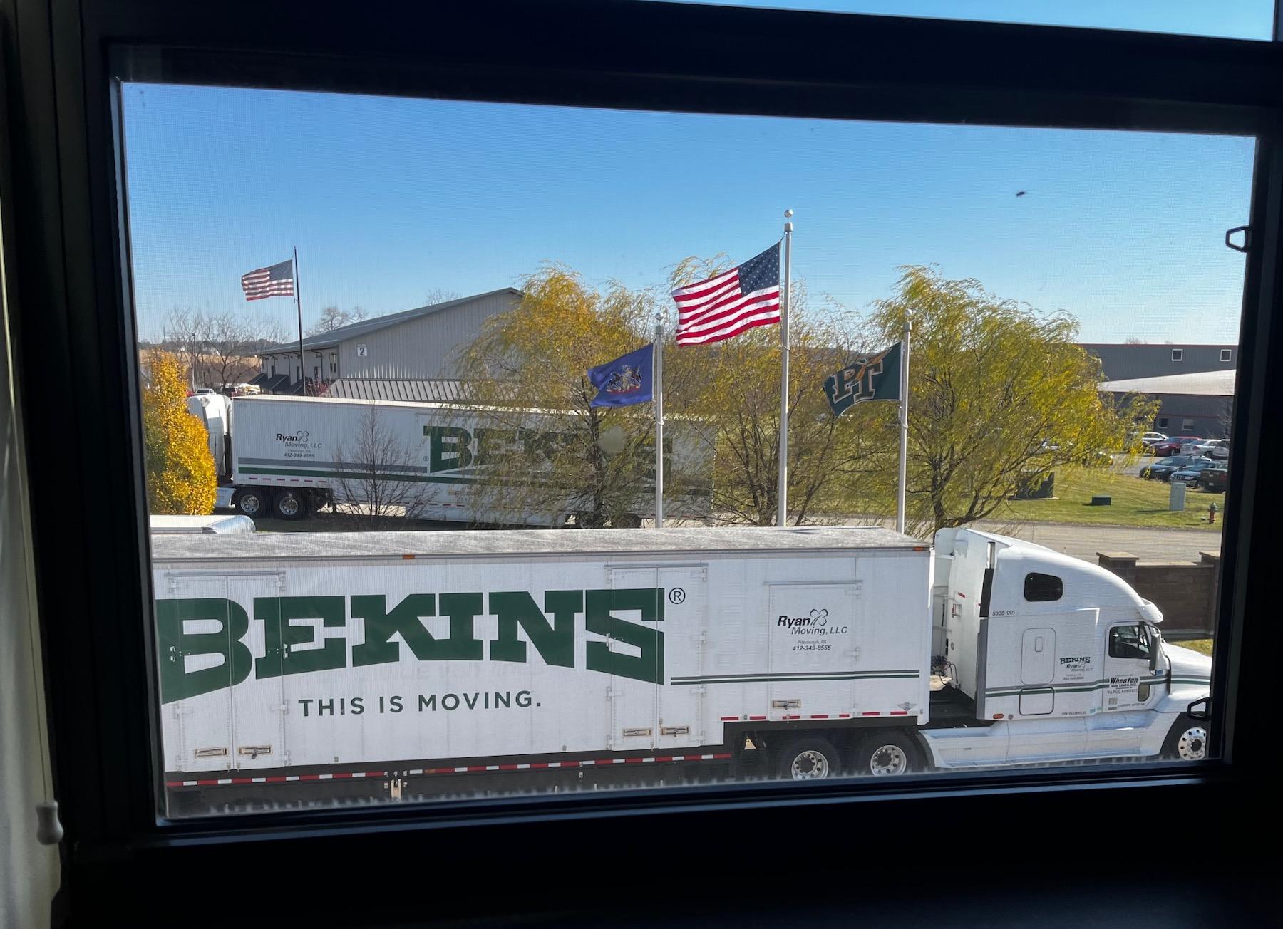 On moving day, the view from an office window framed the flags and the moving trucks