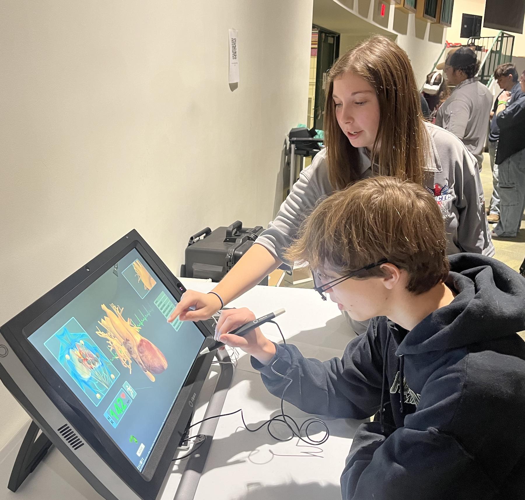 Lizzie Noble directs one of the freshmen on how to use a hands-on computer application